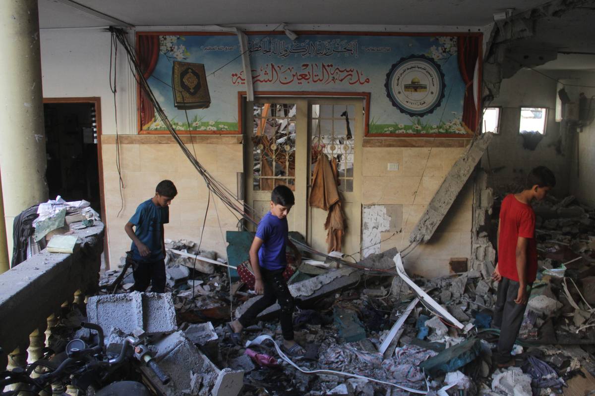 Palestinians children inspect the destroyed building after an Israeli attack at the Et-Tabiin school in the Ed-Deraj neighborhood in Gaza City, Gaza. [Mahmoud İssa – Anadolu Agency]