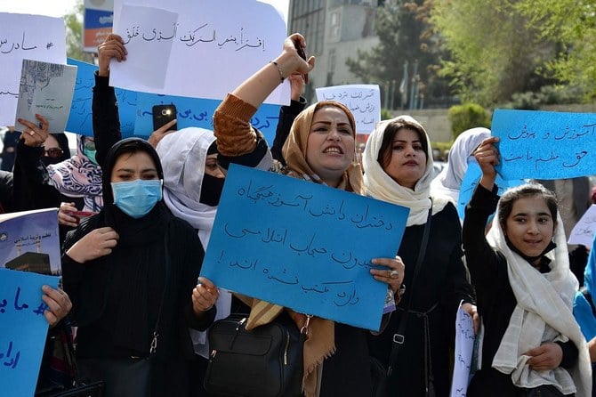 Afghan women chant and hold signs of protest during a demonstration in Kabul, Afghanistan today.