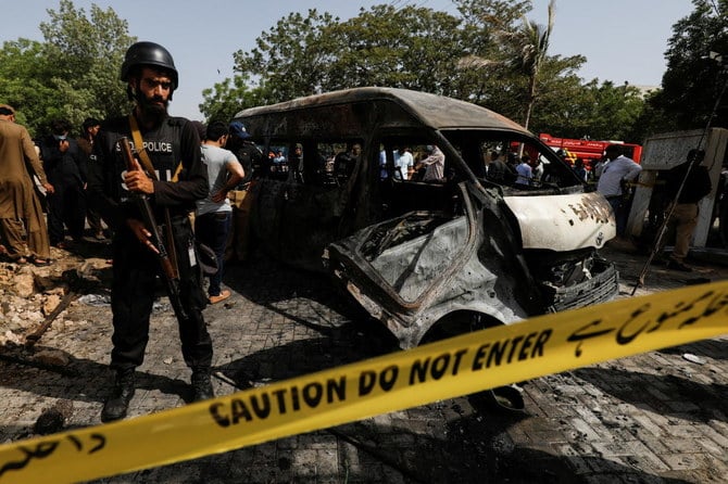 Police officers and crime scene unit gather near a passenger van, after a blast at the entrance of the Confucius Institute University of Karachi, Pakistan.