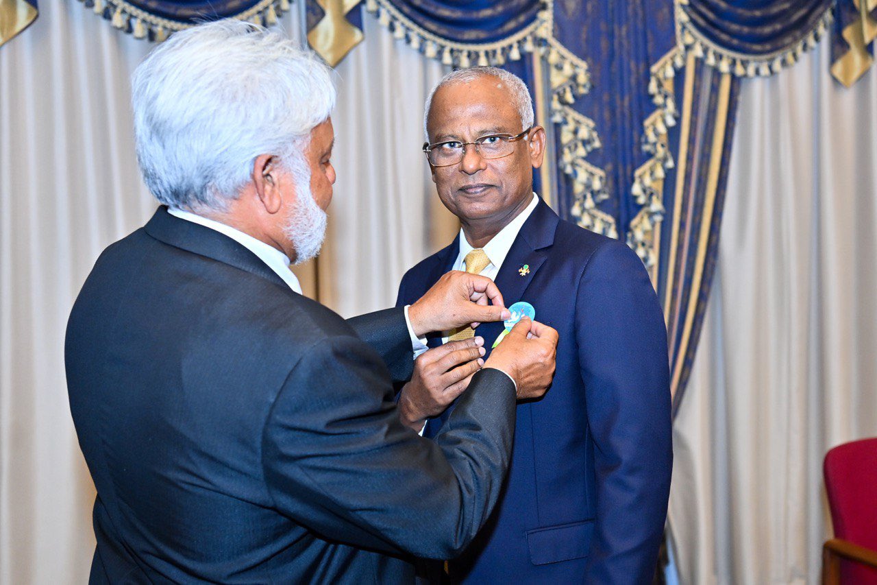 President  receiving a badge recognizing the International Day of Non-Violence.