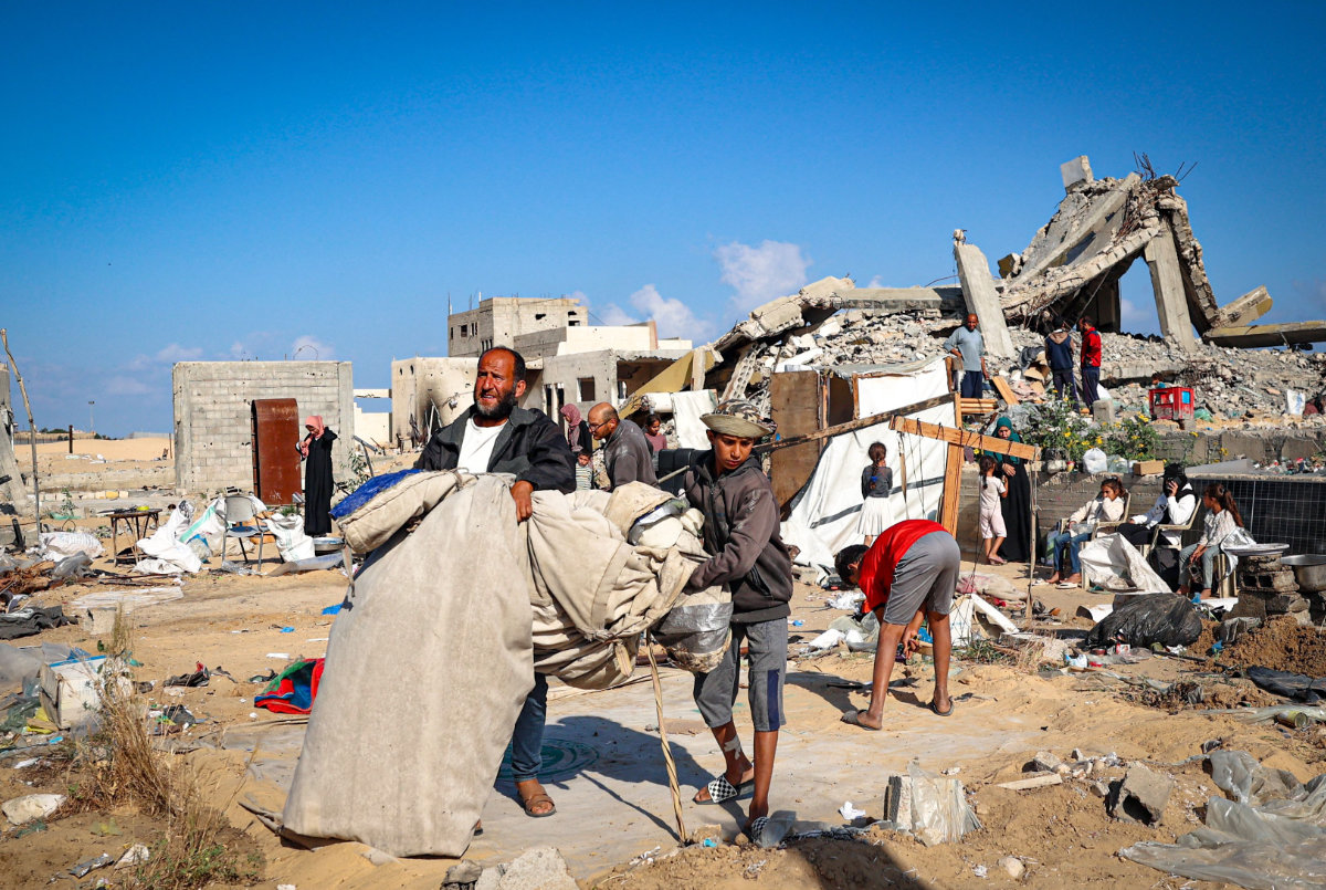 Displaced Palestinians pack their belongings after dismantling their tents before leaving an unsafe area in Rafah on May 15, 2024. (AFP)