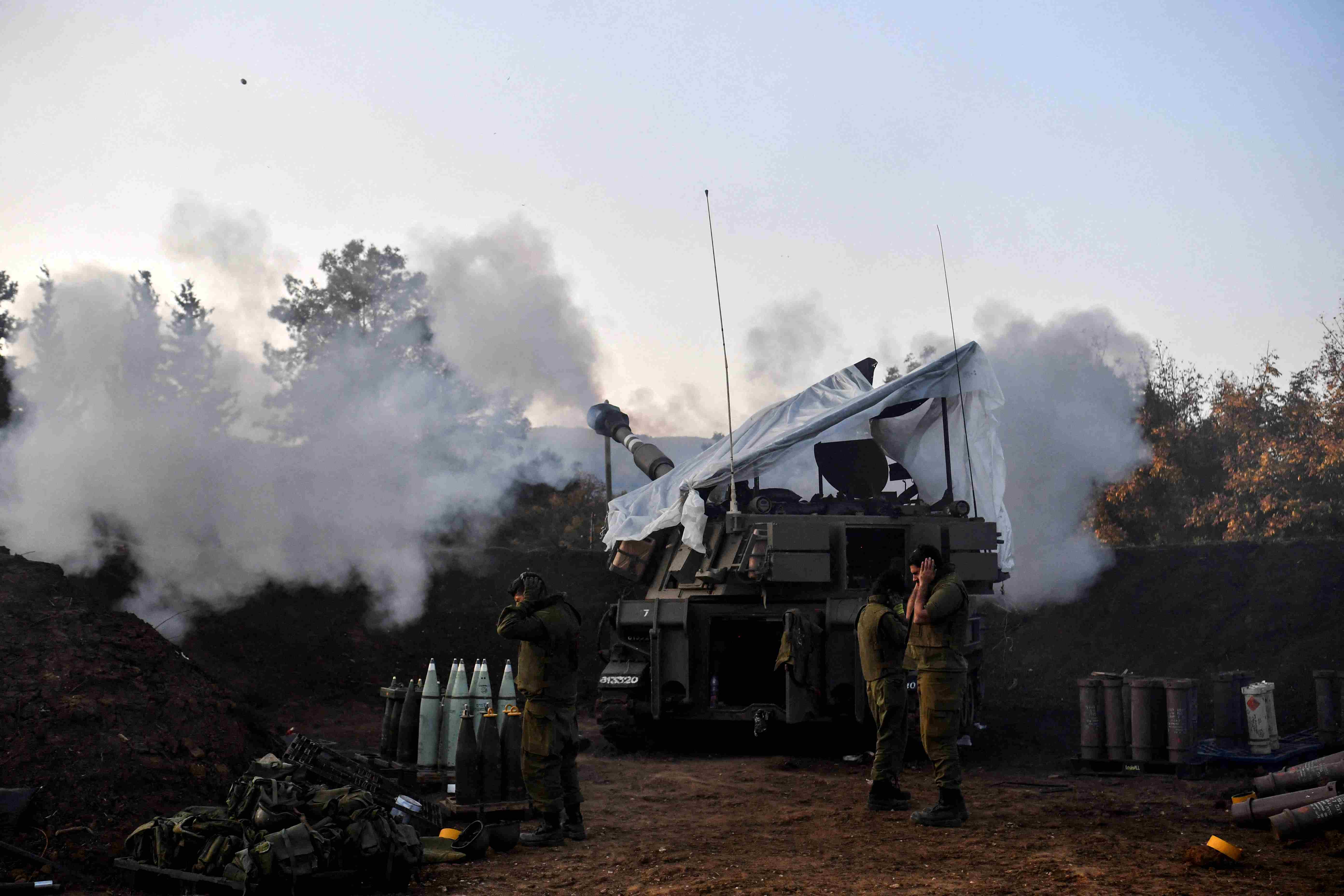 Israeli soldiers stand by, as a mobile artillery unit fires, on the Israeli side of the Israel-Lebanon border, REUTERS.