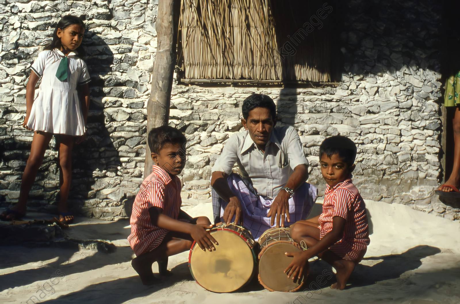 A father instructs his two sons in the use of traditional drums in one of the islands of Maldives in 1980. Photo: Social Media