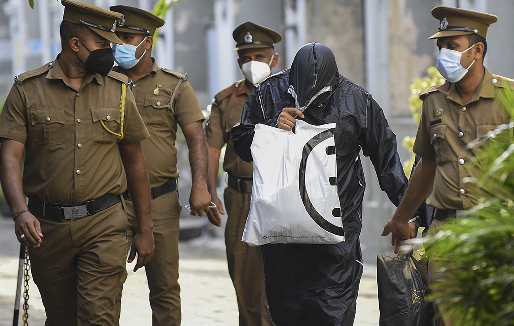 Sri Lanka's prison officials escort former state minister for Finance and Treasury Mohamed Ashmalee, out of the Colombo Fort Magistrate’s court in Colombo. (Photo: AFP)