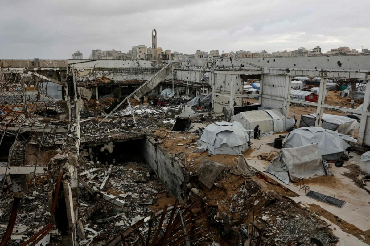 makeshift shelters inside a war-damaged building, parts of which collapsed on a windy winter day in Gaza City on Tuesday (AFP photo)