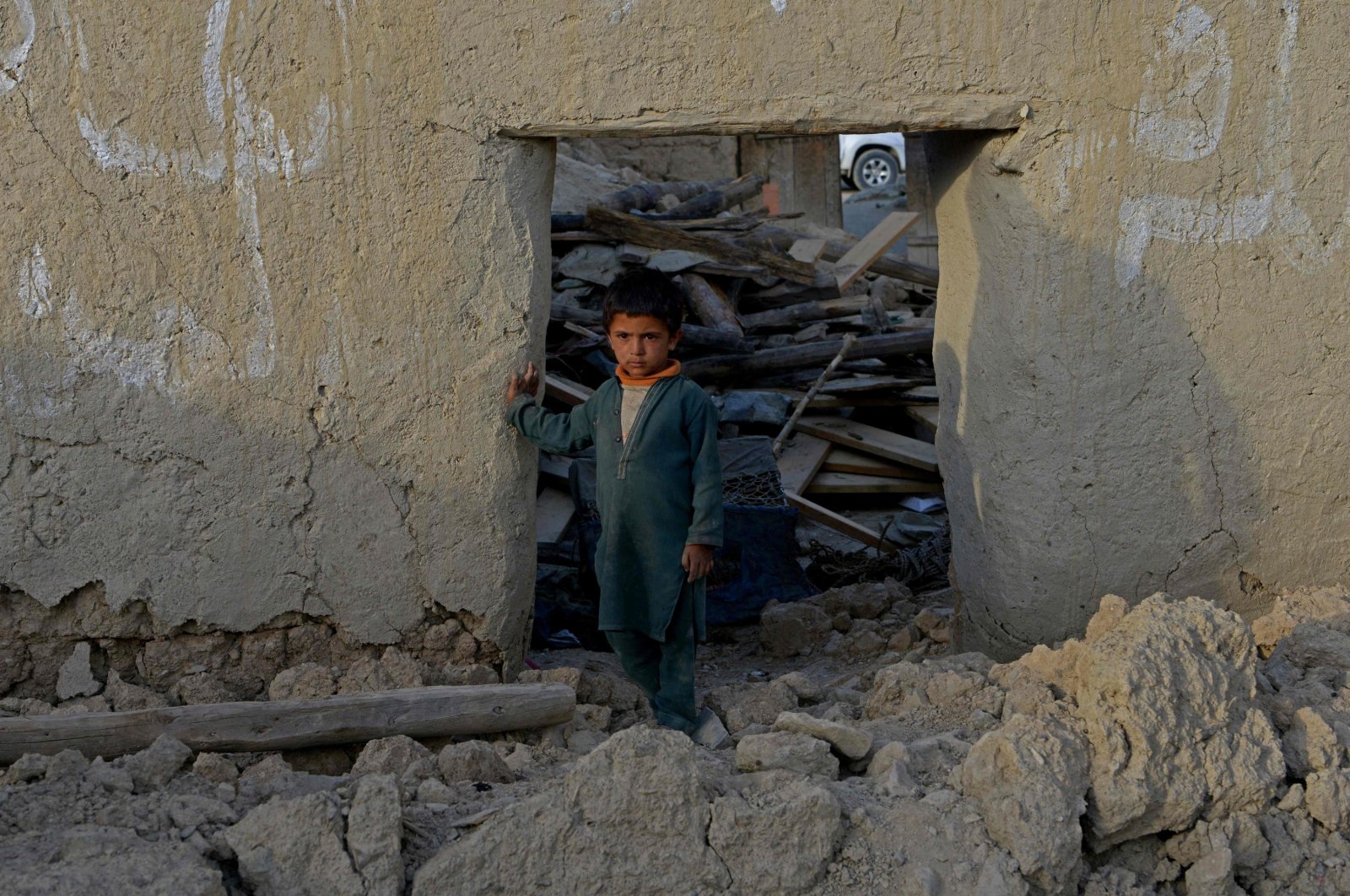 A boy stands inside a damaged house after a the earthquake in June. (AFP Photo).