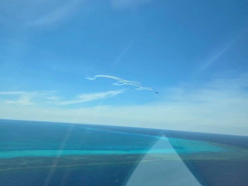 This handout photo from the Philippine Coast Guard (PCG) taken on August 19, 2024, shows a Chinese air force fighter jet deploying flares near a Philippine BFAR plane