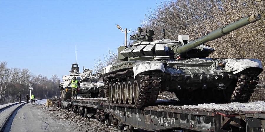 Russian army tanks are loaded onto railway platforms to move back to their permanent base after drills in Russia. Russia says it is returning more troops and weapons to bases. (Photo | AP)