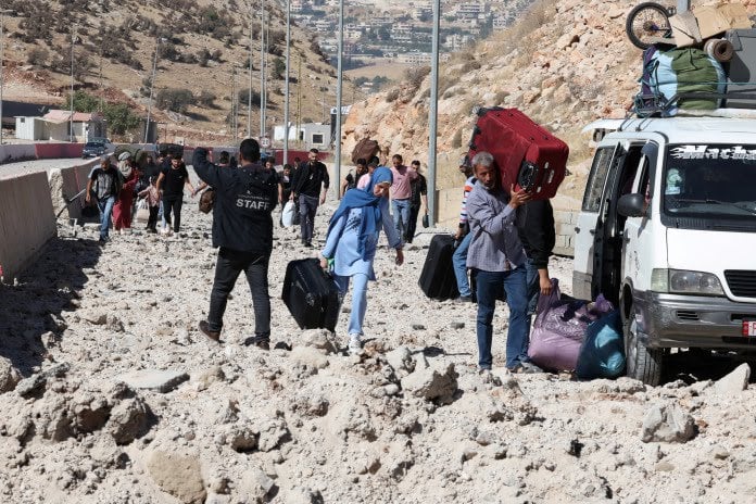 People fleeing Lebanon due to ongoing hostilities between Hezbollah and Israeli forces, at Masnaa border crossing with Syria, in Lebanon, October 4, 2024. (REUTERS)