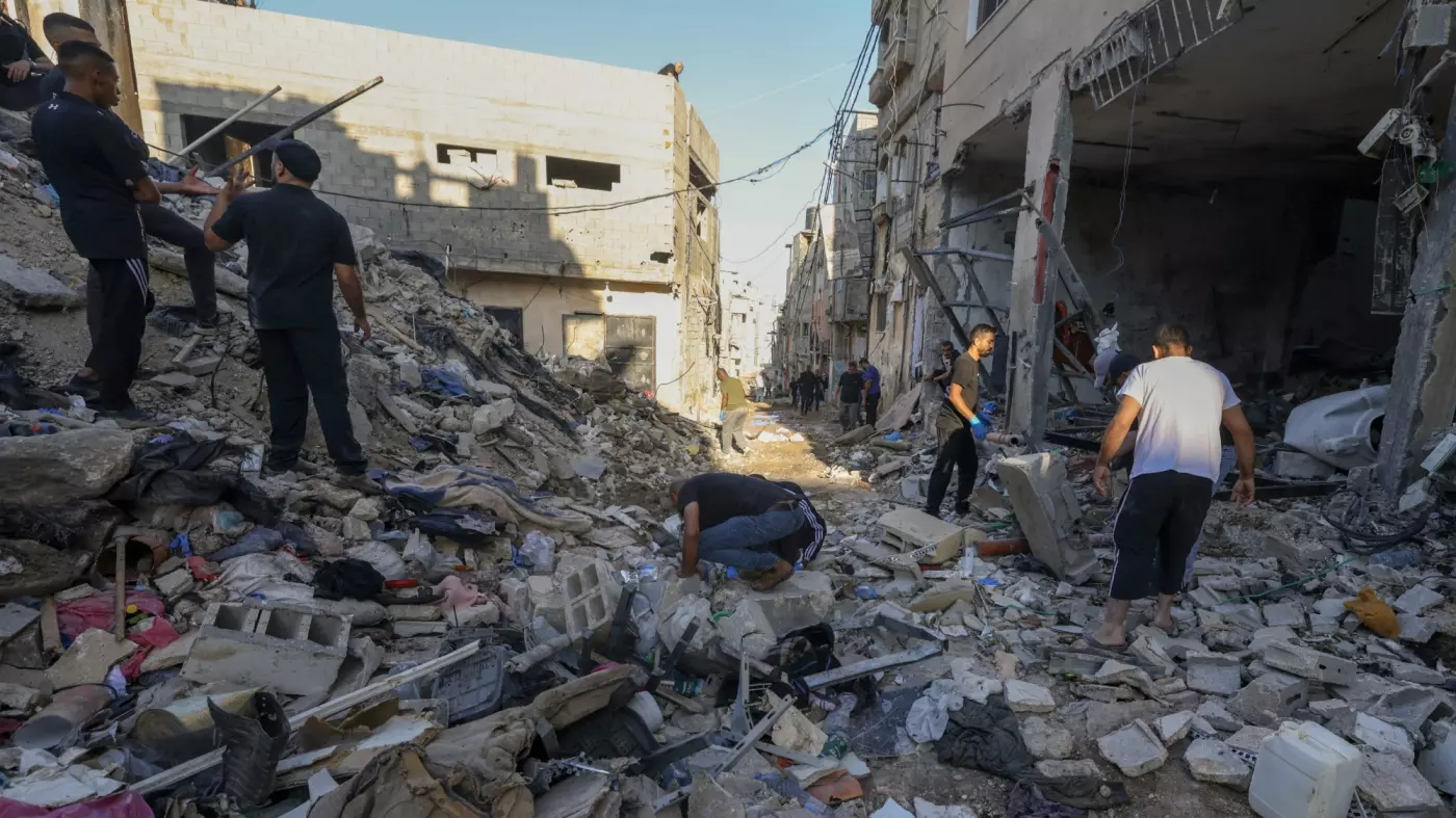 Palestinians inspect the damage at the site of an overnight Israeli air strike on the Tulkarem refugee camp in the occupied West Bank on 4 October 2024 (AFP)