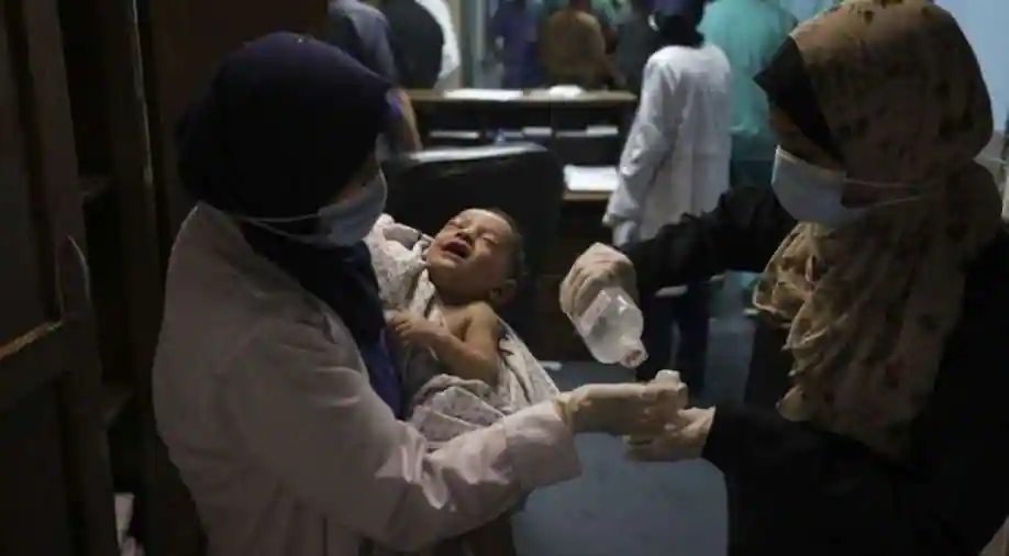 A nurse holds a Omar al-Hadidi, at Al-Shifa Hospital, in Gaza City early on May 15, 2021.