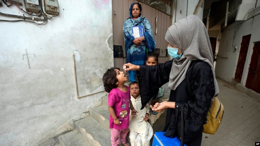 A health worker administers a polio vaccine to a child in Karachi, Pakistan, 2023