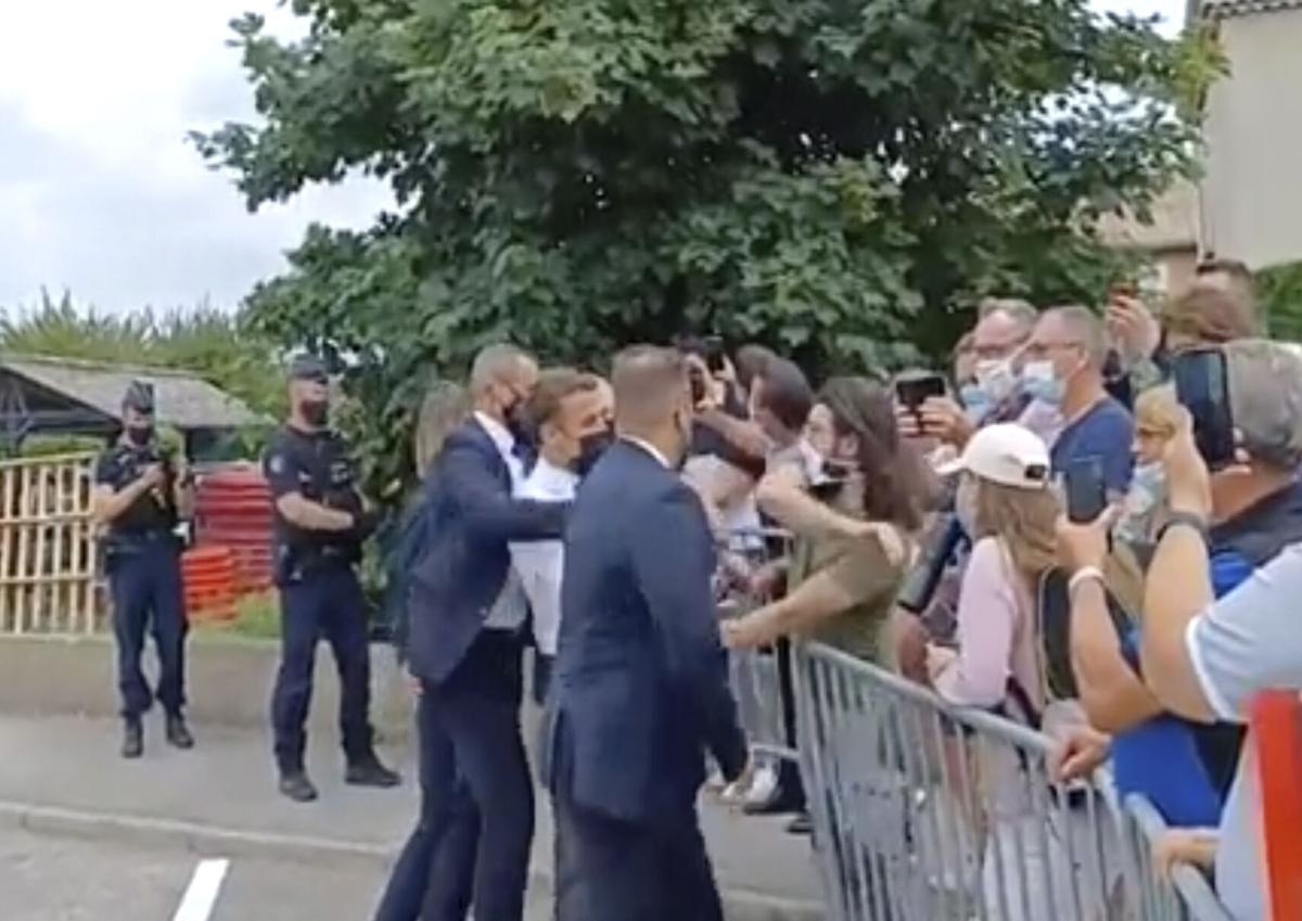 In this grab taken from video France’s President Emmanuel Macron, centre, is slapped by a man, in green T-shirt, on Tuesday, June 8, 2021.