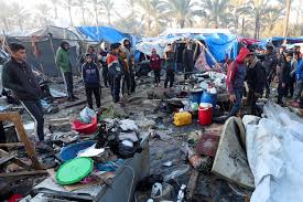 Palestinians inspect the site of an Israeli strike on a tent camp for displaced people, amid the ongoing conflict, in Deir Al-Balah in the central Gaza Strip, January 14, 2025. REUTERS