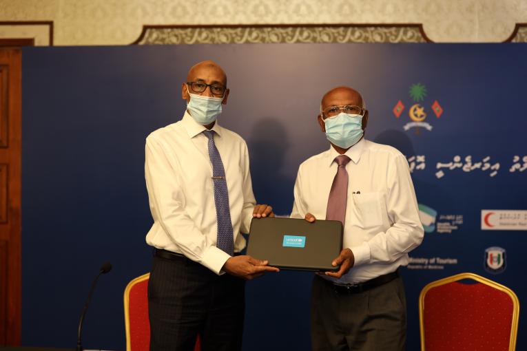 Minister of Health Ahmed Naseem receiving the 46 laptops and 5,000 PCR test kits donated by the UNICEF. Photo: UNICEF Maldives/ Social Media.