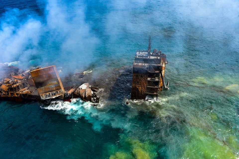 A layer of green film blanketing the ocean surrounding the vessel the MV X-Press Pearl vessel as it sinks.