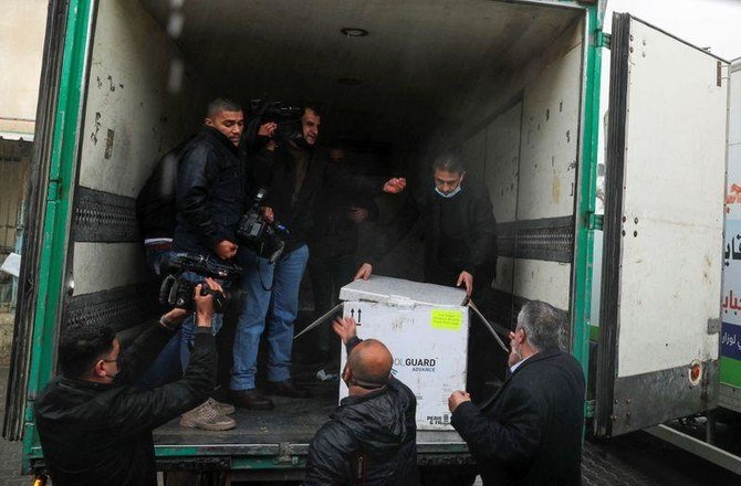 Palestinians unloading a batch of the first shipment of the Covid vaccines in Gaza City.