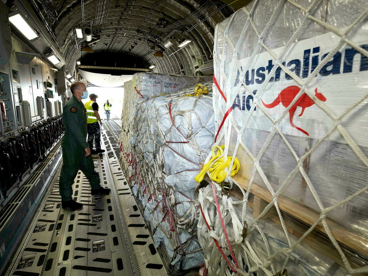 Australian Air Force Load Master Corporal Dale Hall inspecting pallets of aid bound for Tonga at RAAF Base Amberley.