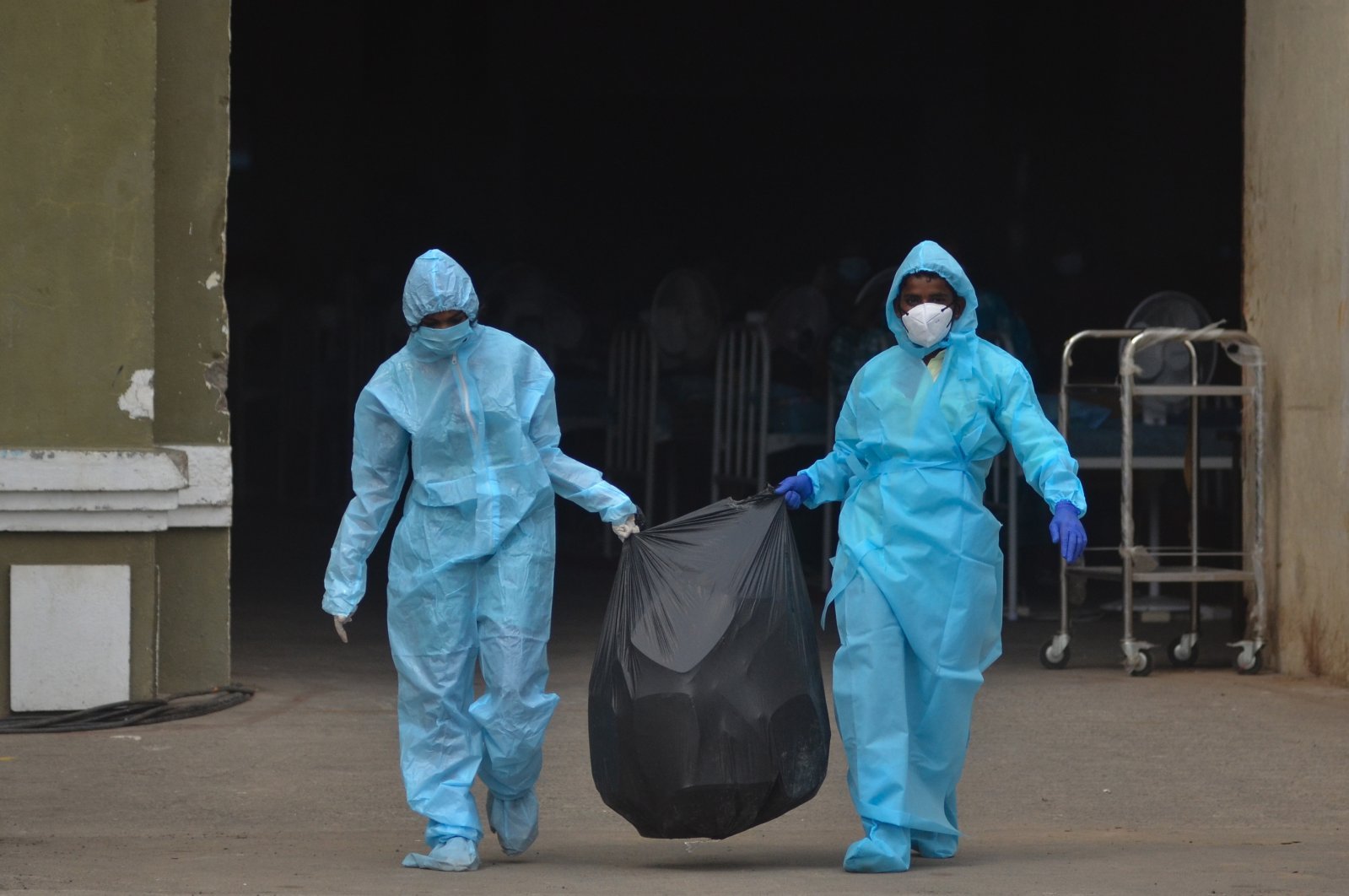 Indian health workers carrying medical waste for disposal.