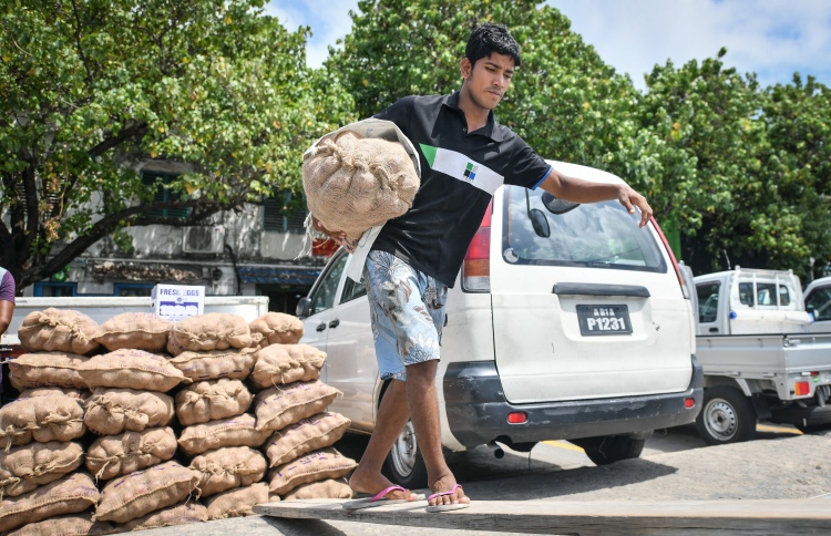 Onions being loaded from a pickup to a dhoni.