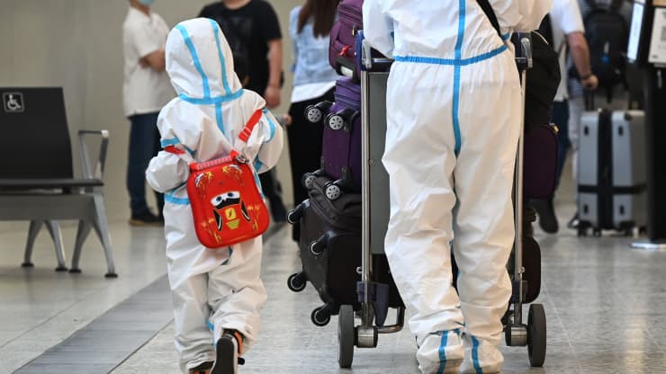 Travelers wearing PPE arrive at Melbourne’s Tullamarine Airport.