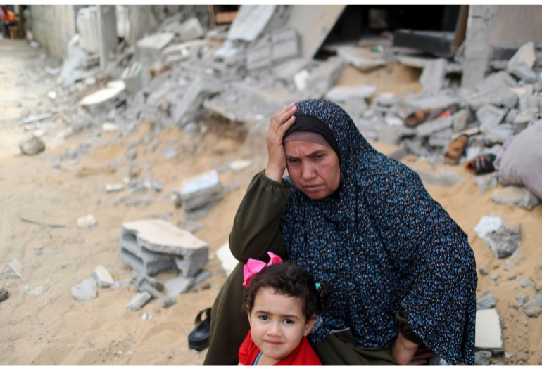 A Palestinian woman puts her hand on her head after returning to her destroyed house. Photo: Reuters.